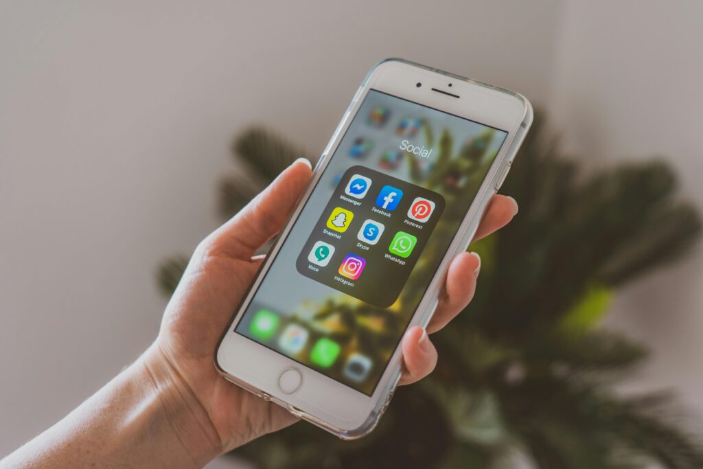 pexels photo 4114787 4114787 Close-up of a hand holding a smartphone displaying popular social media apps.